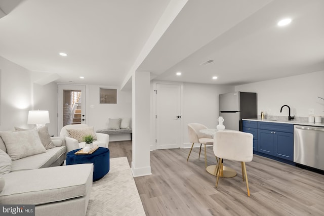 living room with sink and light hardwood / wood-style floors