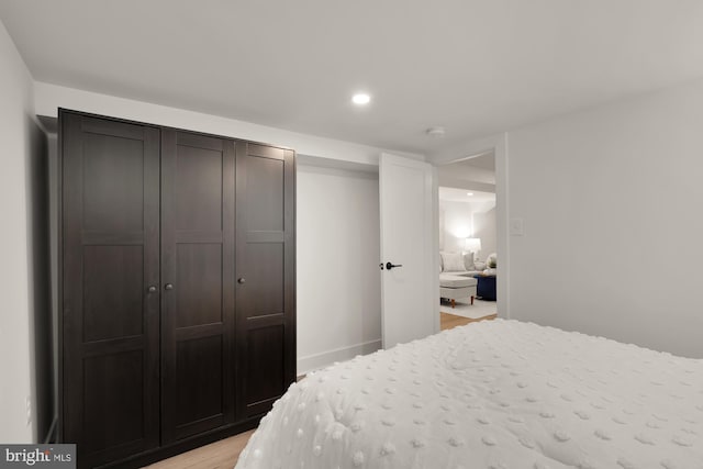 bedroom with light wood-type flooring and a closet