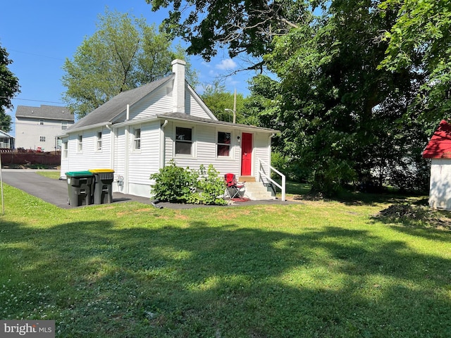 rear view of property featuring a yard