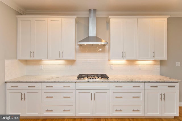 kitchen featuring ornamental molding, wall chimney exhaust hood, and white cabinets