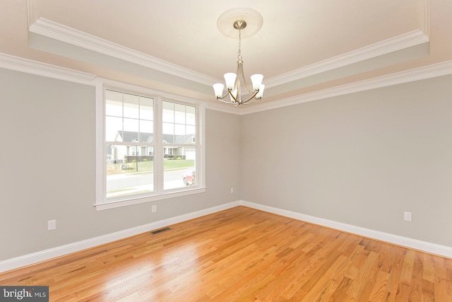 spare room with ornamental molding, light hardwood / wood-style flooring, and a notable chandelier