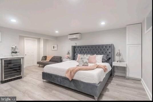 bedroom featuring light wood-type flooring, wine cooler, and a wall mounted AC