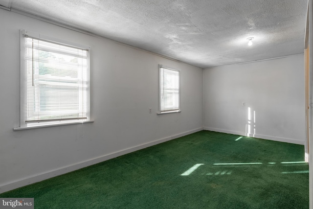 carpeted spare room featuring a textured ceiling