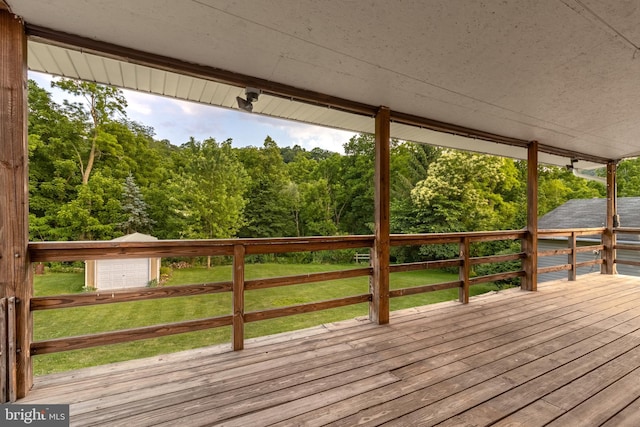 wooden terrace featuring a lawn