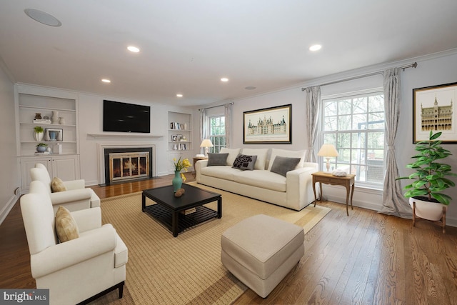 living room with crown molding, hardwood / wood-style floors, and a healthy amount of sunlight