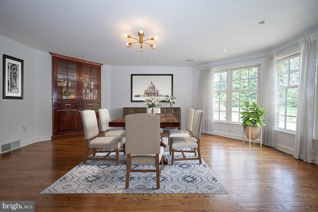 dining space featuring wood-type flooring and a notable chandelier