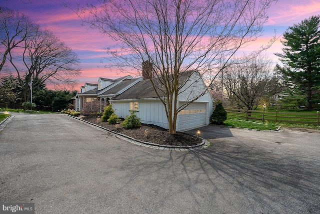 property exterior at dusk featuring a garage