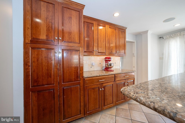 kitchen featuring tasteful backsplash, light stone counters, and light tile patterned flooring