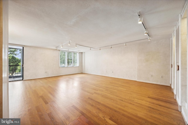 unfurnished room with a textured ceiling and light hardwood / wood-style flooring