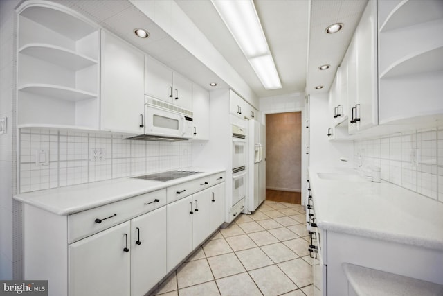 kitchen with white cabinetry, white appliances, backsplash, and light tile patterned floors