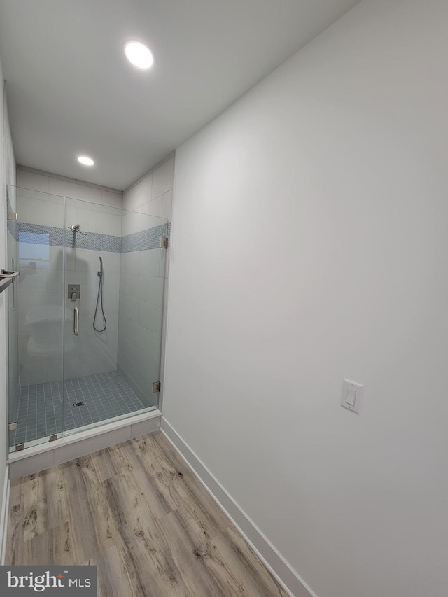 bathroom featuring hardwood / wood-style floors and a shower with door