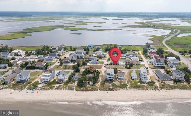 drone / aerial view featuring a beach view and a water view