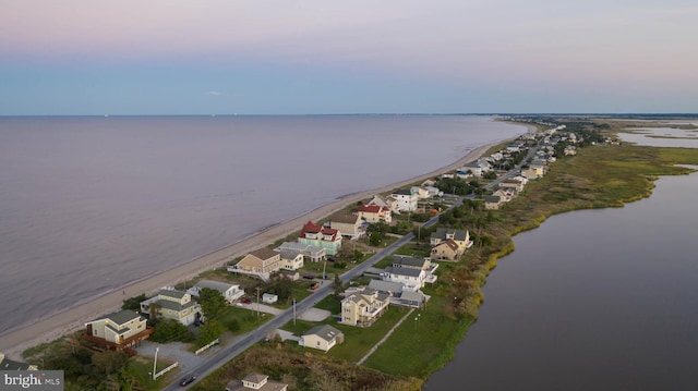 aerial view at dusk featuring a water view