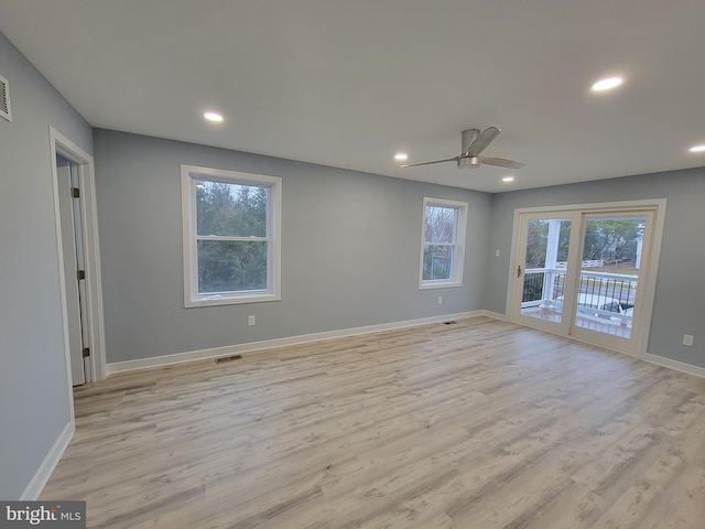 empty room with light hardwood / wood-style floors, ceiling fan, and a healthy amount of sunlight