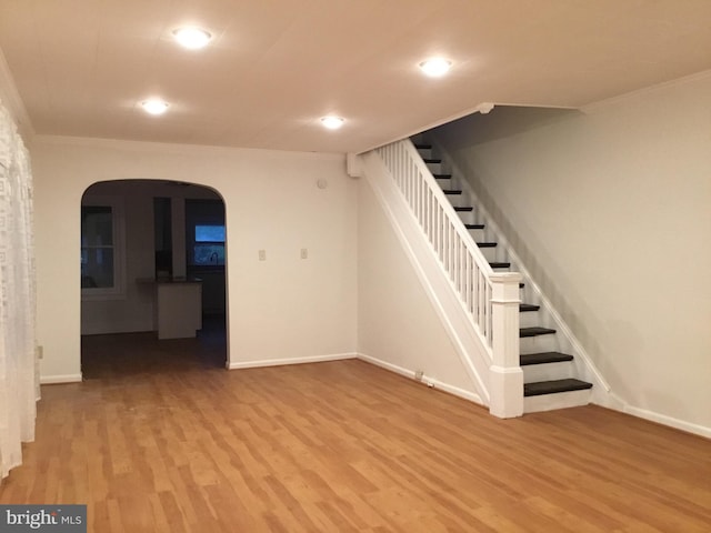 stairs featuring light wood-type flooring and ornamental molding