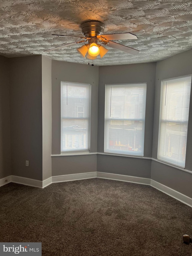 carpeted empty room with ceiling fan and a healthy amount of sunlight