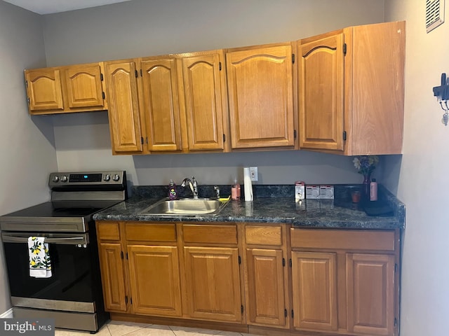 kitchen featuring stainless steel electric range oven, sink, and light tile patterned floors