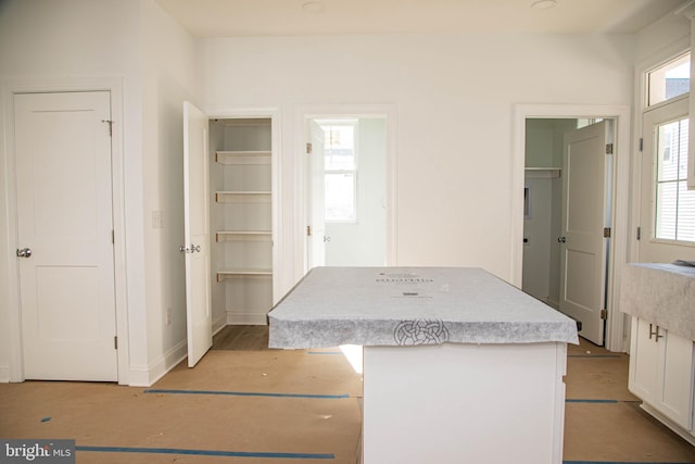 interior space with white cabinets, light countertops, and a center island