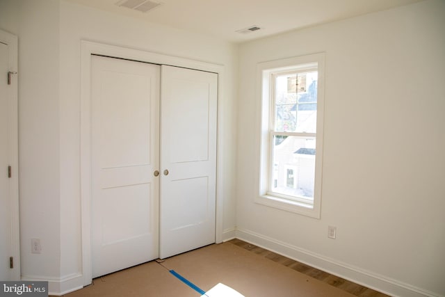 unfurnished bedroom with light wood-style floors, a closet, visible vents, and baseboards