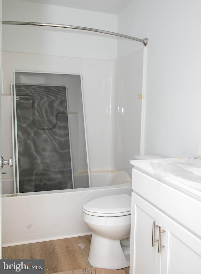 full bath with vanity, bathing tub / shower combination, wood finished floors, and toilet