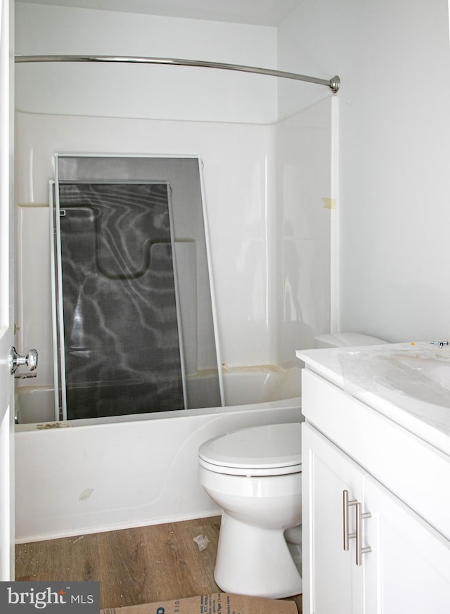 full bath featuring bathtub / shower combination, vanity, toilet, and wood finished floors