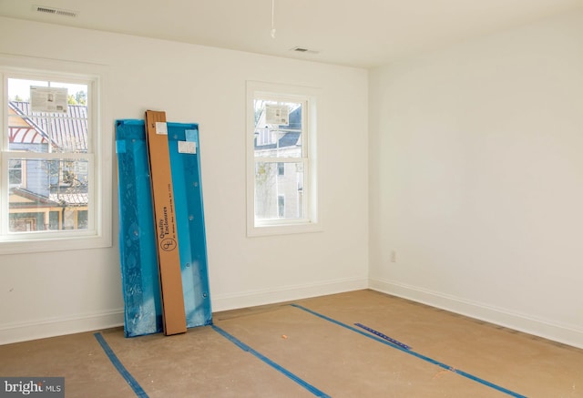 unfurnished bedroom with concrete flooring, visible vents, and baseboards