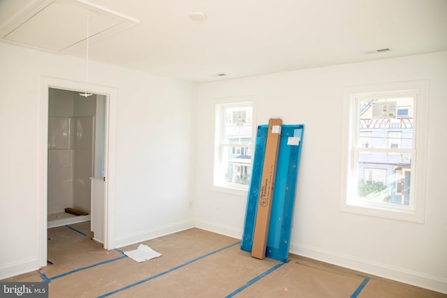 unfurnished bedroom with visible vents, attic access, and baseboards