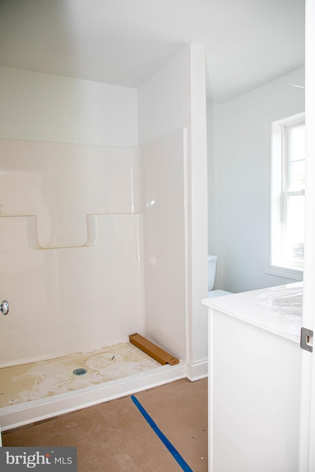 bathroom featuring concrete floors, vanity, and walk in shower