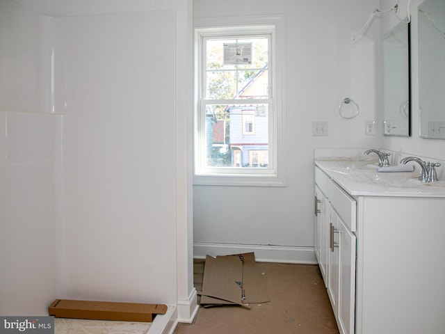 full bathroom with a healthy amount of sunlight, vanity, and baseboards