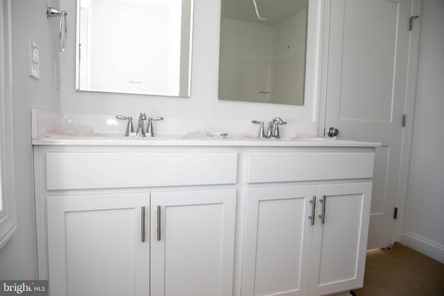 full bathroom with double vanity and a sink