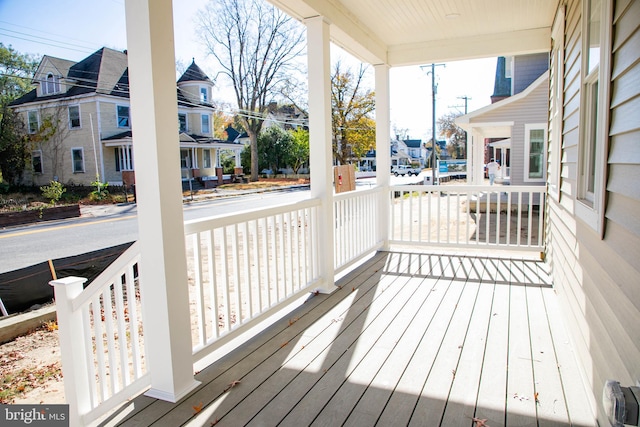 deck featuring covered porch and a residential view