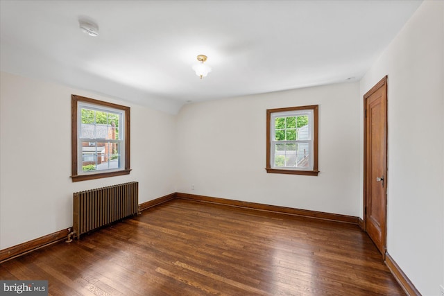 empty room featuring dark hardwood / wood-style flooring and radiator