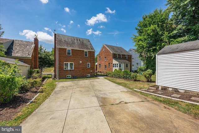 rear view of property featuring a storage shed