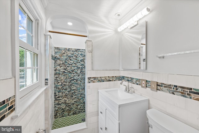 bathroom with vanity, toilet, an enclosed shower, and tile walls