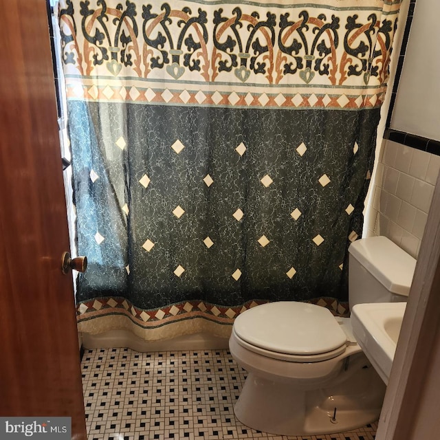 bathroom featuring tile walls, toilet, and tile patterned flooring