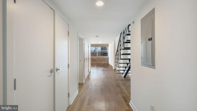 hall featuring electric panel and light hardwood / wood-style flooring