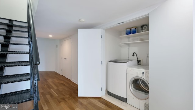 laundry area featuring washer and dryer and light hardwood / wood-style floors