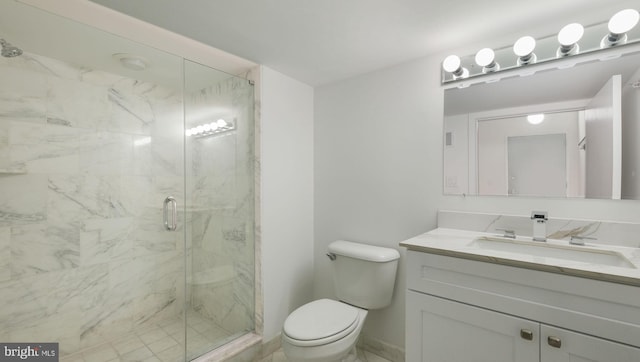 bathroom featuring vanity, toilet, and a shower with door