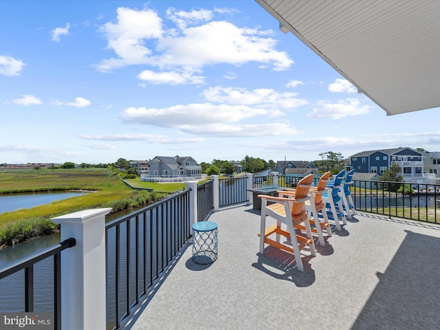 view of patio / terrace featuring a water view and a balcony