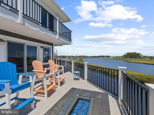 view of patio featuring a water view and a balcony