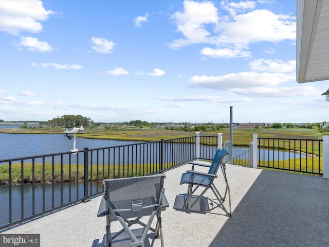 view of patio / terrace featuring a water view and a balcony