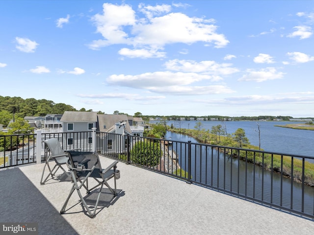 view of patio with a balcony and a water view