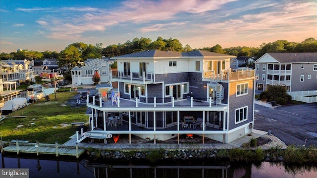 back house at dusk featuring a balcony