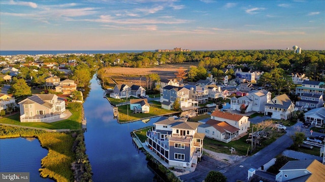 aerial view at dusk featuring a water view