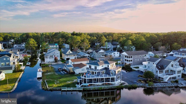 aerial view at dusk featuring a water view