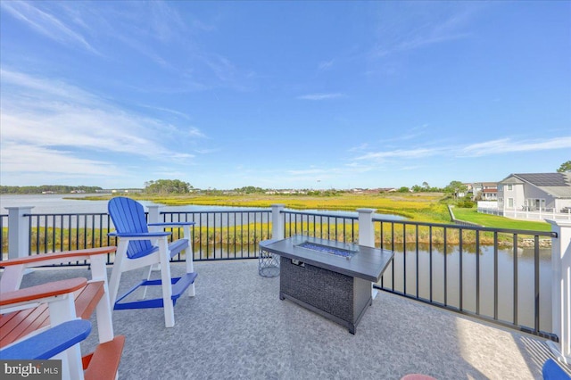 view of patio with a water view and an outdoor fire pit