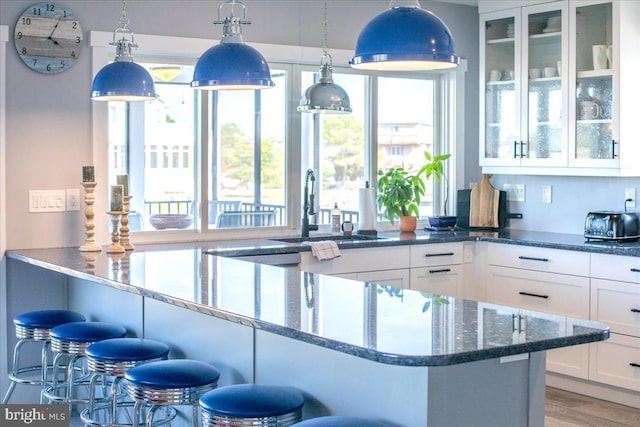 bar featuring white cabinetry, sink, and pendant lighting