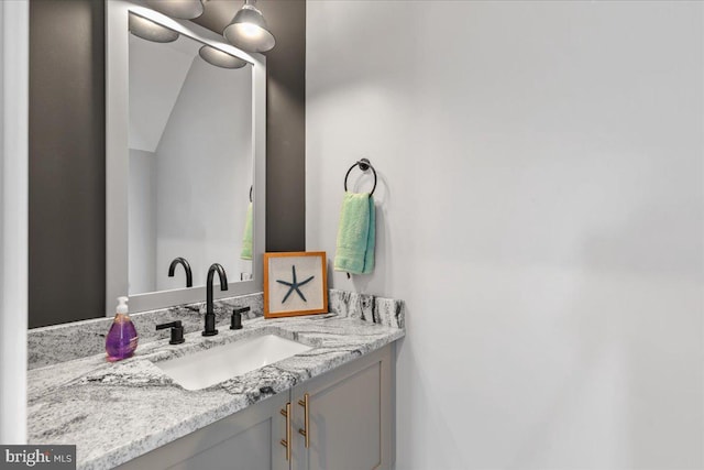 bathroom featuring vanity and lofted ceiling