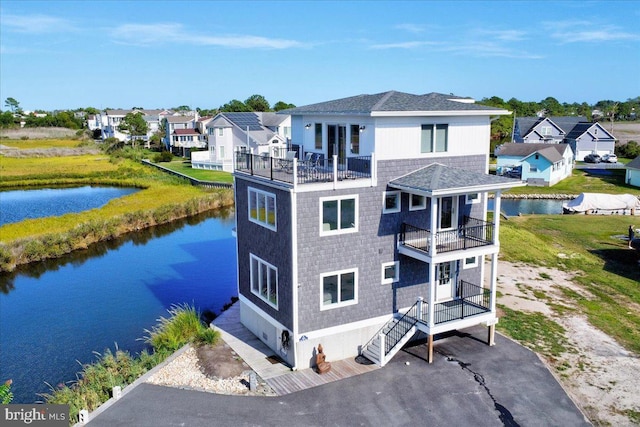 back of house featuring a balcony and a water view