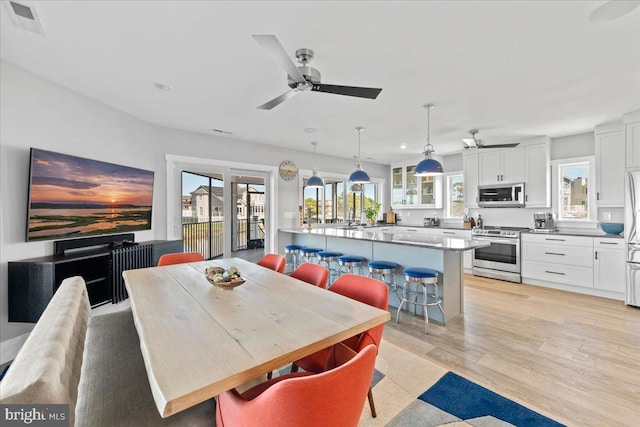 dining space featuring ceiling fan, a healthy amount of sunlight, and light wood-type flooring